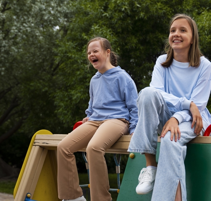 Ninos-sonrientes-tiro-completo-sentados-juntos